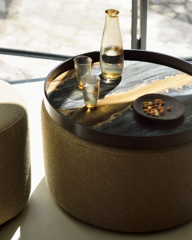 Tray with yellow toned carafe and glasses with nuts on plate highlighting how the sun and shadows change the feel