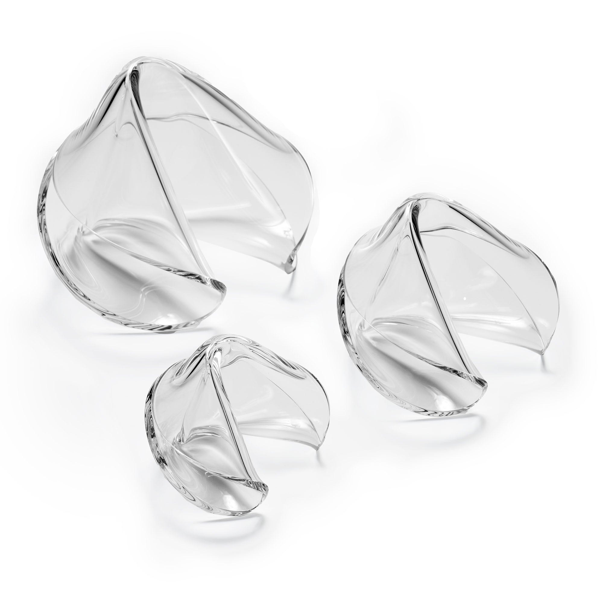 Three clear acrylic fortune cookie sculptures in different sizes on a white background