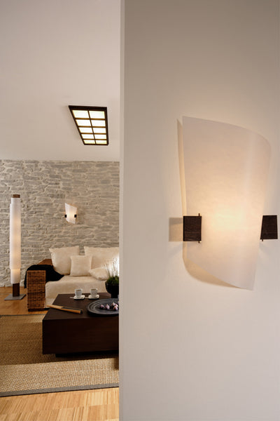 Domus Licht PLAN B Wall Sconce in a warm indoor environment with lights in foreground and background GALLERY