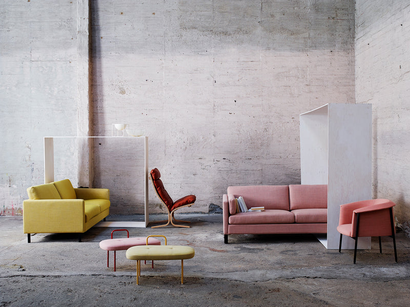 Red Siesta Chair with other LK Hjelle Sofas, ottomans and chairs with a soft colorful palette with white background and concrete flooring GALLERY