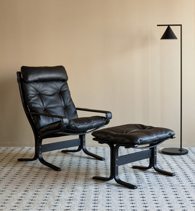 Siesta all black chair including leather and frame with modern black triangle floor lamp on beige background GALLERY